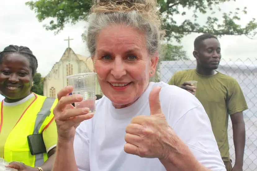Mama Dream Village (Liesbeth van Vemden) drinks the purified water at Anyinamae