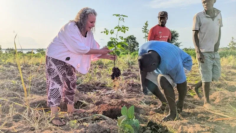 Mama Dream Village and a young volunteer planting a tree at sunset on the Dambai farm